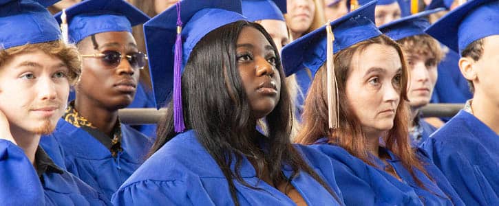 FLCC graduates in blue gowns and caps on commencement day, preparing for their future careers.