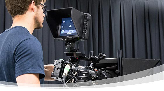 Student operating a video camera in a studio