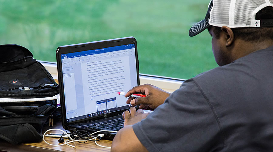 Student reviewing a Word document on a laptop computer