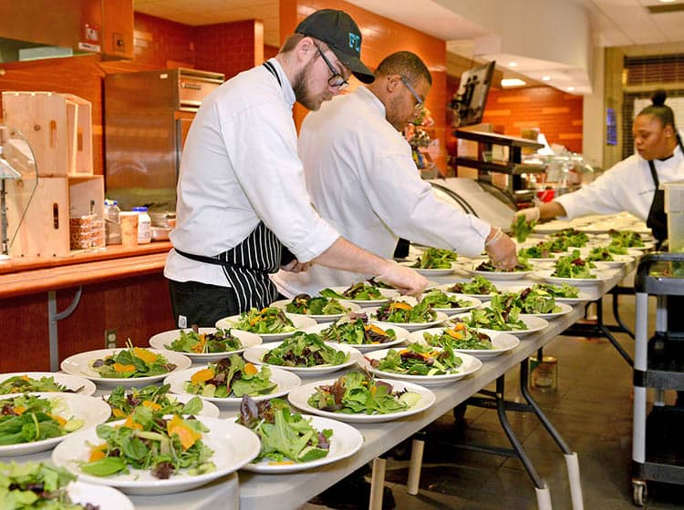 A group of culinary students prepare food for community members attending the annual Dinner at Julia event.
