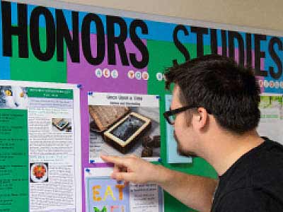 Student checking out Honors Studies learning opportunities on an information board
