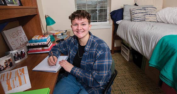 An FLCC student studying in a private bedroom at The Suites at Laker Landing.