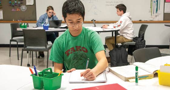 A student working from a textbook at the FLCC Math Center.