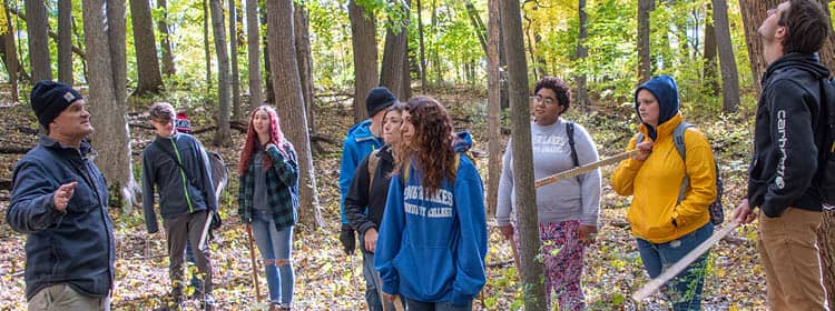 FLCC staff leads an outdoor wellness program in a forest.